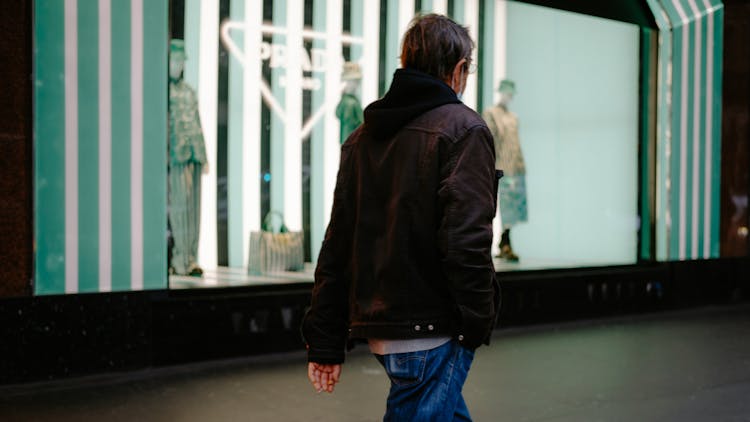 A Man Walking In A City At Night