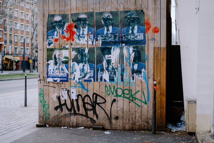 Ripped Posters On Brown Wooden Wall