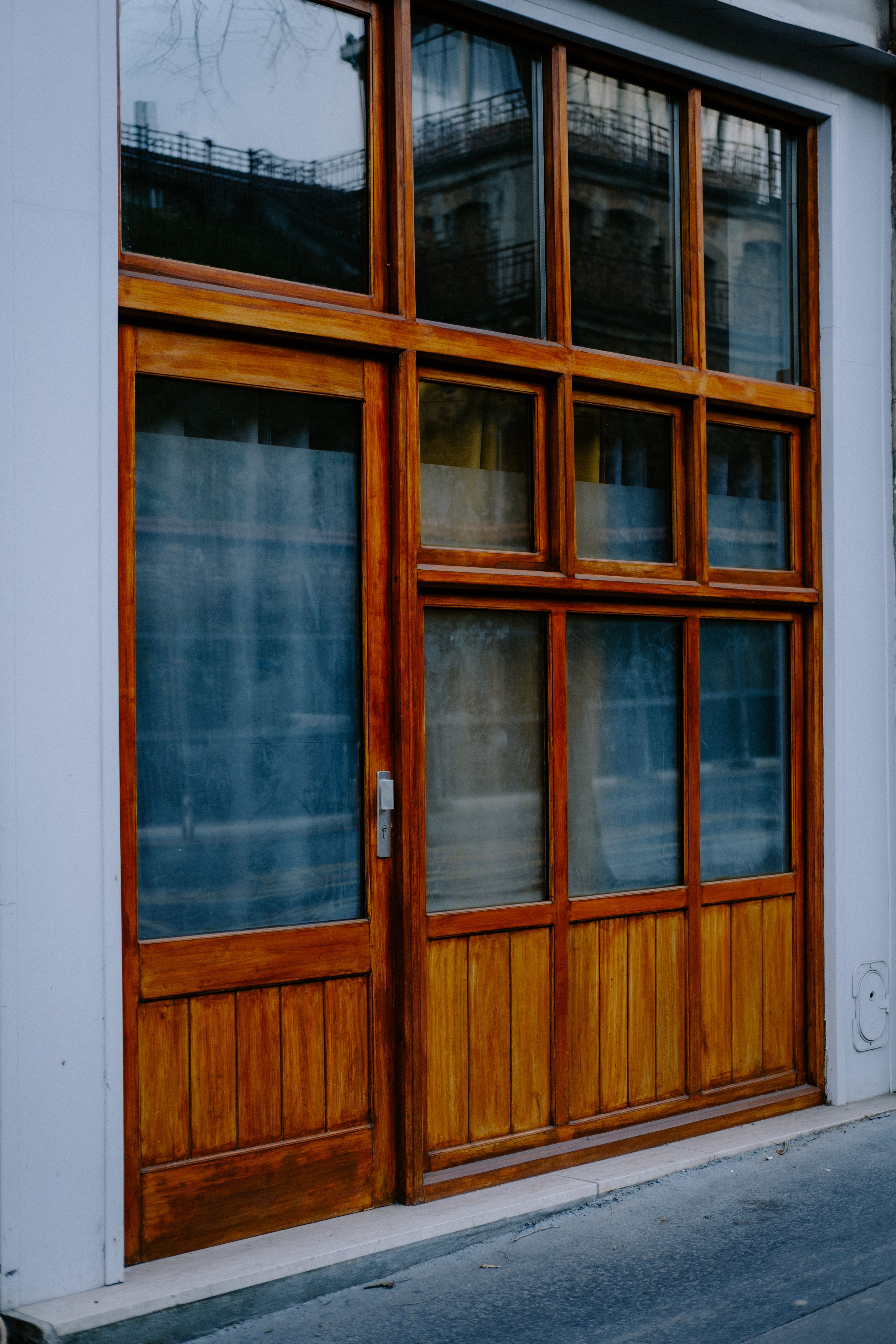 Devanture de boutique à menuiserie de bois et vitrages à petits carreaux, vue depuis le trottoir