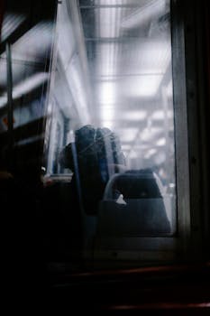 View through a train window capturing a serene ambiance with reflections and lighting.