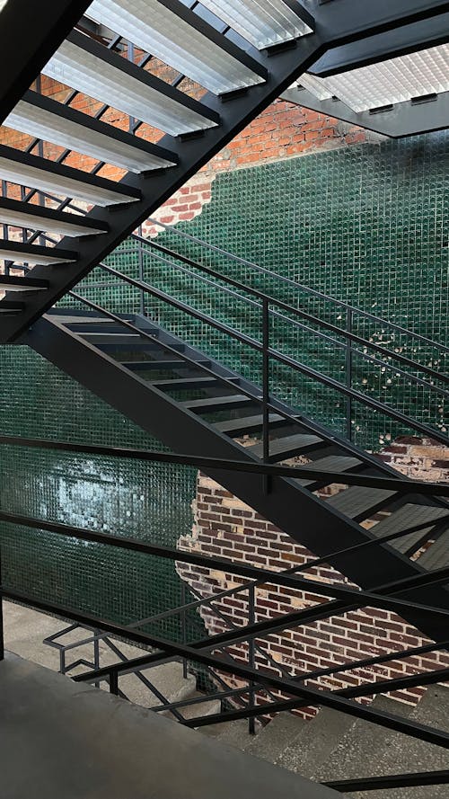 Gray Metal Stairway Near Brick Wall