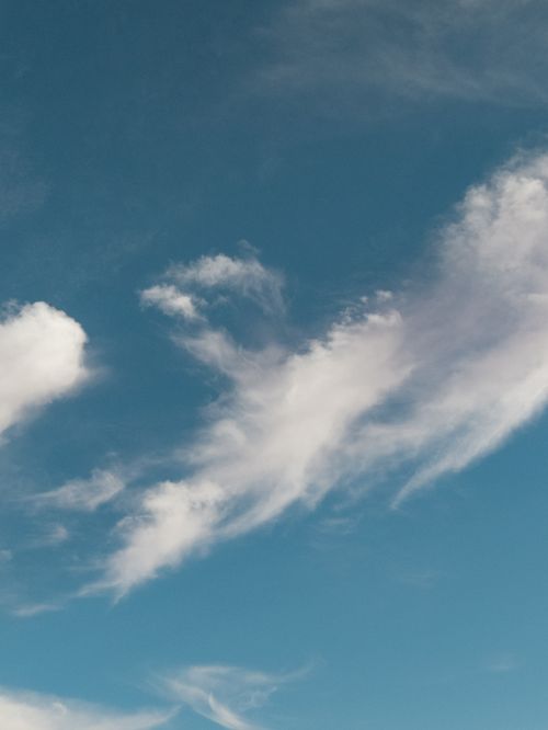 Free A tranquil view of a blue sky filled with wispy white clouds, perfect for nature themes. Stock Photo