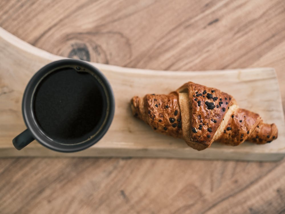 Free A Cup of Coffee beside a Croissant Stock Photo