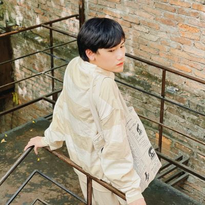 Person in a sand-coloured jacket on a stairwell — photo by Joen Nguyen on Pexels