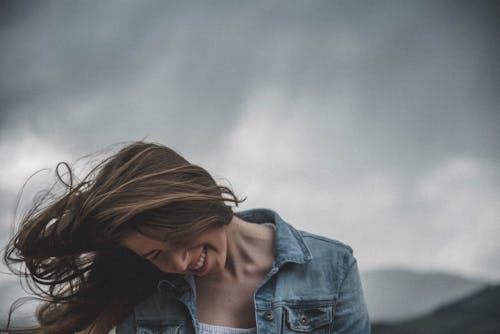 Woman Wears Blue Denim Top and White Inner Smiling