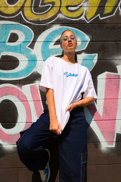 Free A stylish person poses against colorful graffiti, showcasing urban fashion. Stock Photo