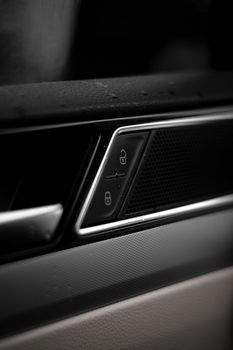 Detailed close-up image of car door lock buttons in a modern vehicle interior.