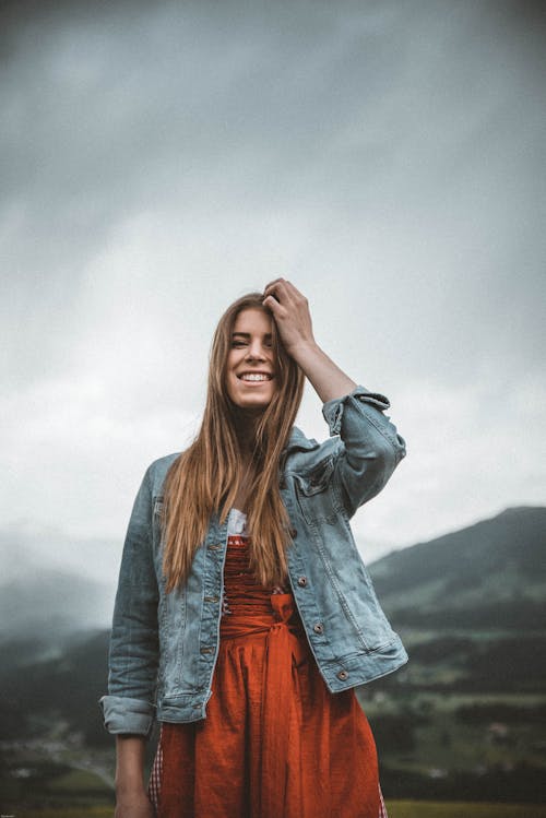 Free Woman Wearing Blue Denim Button-up Jacket Under Heavy Clouds Stock Photo