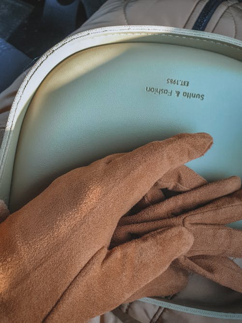 Brown Gloves on Top of Blue Bag