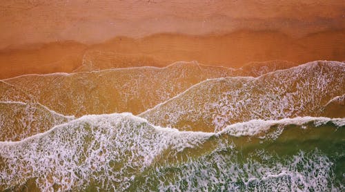 모래 근처의 물 흐름의 항공 사진