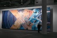 当代画廊中展示着一幅大型未来派艺术品，描绘了齿轮与面孔的组合