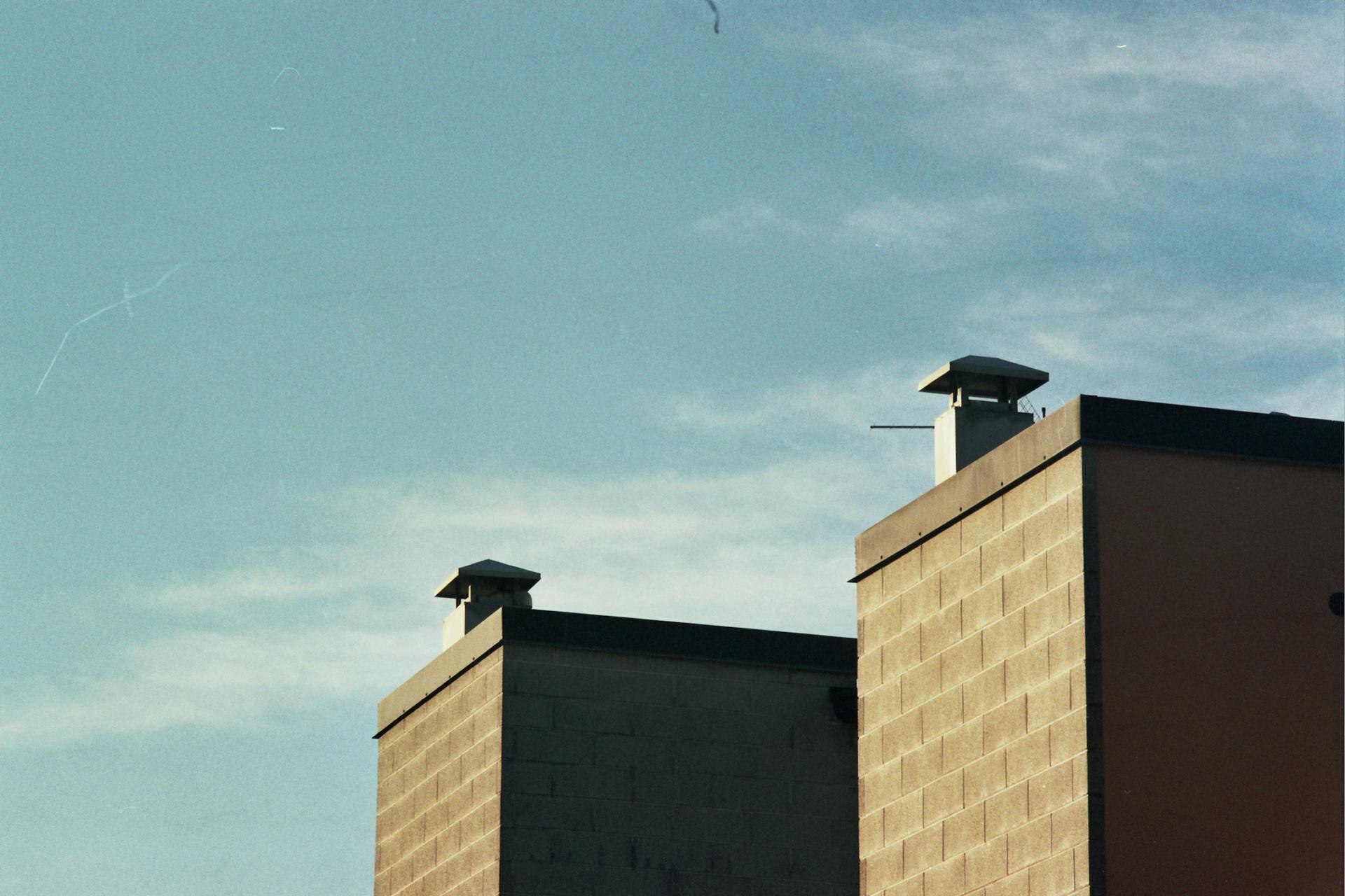 Italian building with chimneys in front of a clear blue sky, showcasing urban architecture.