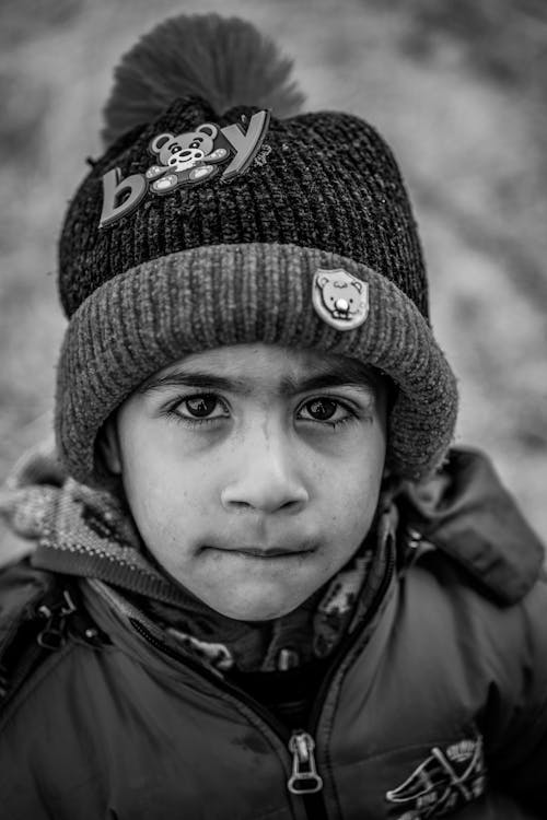 Grayscale Photo of Boy Wearing Knit Cap and Jacket