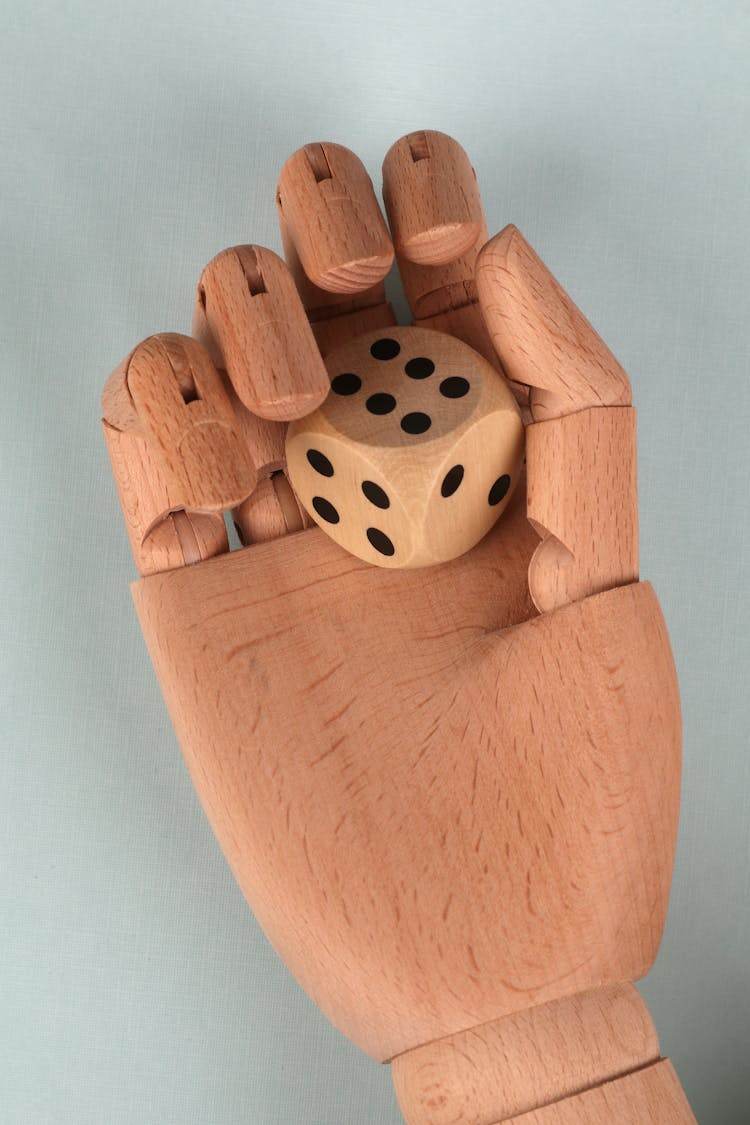 Brown Wooden Hand Holding A Dice