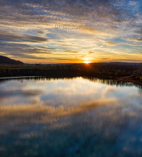 Free A breathtaking sunset reflecting on a serene lake in Rochester, Minnesota. Stock Photo