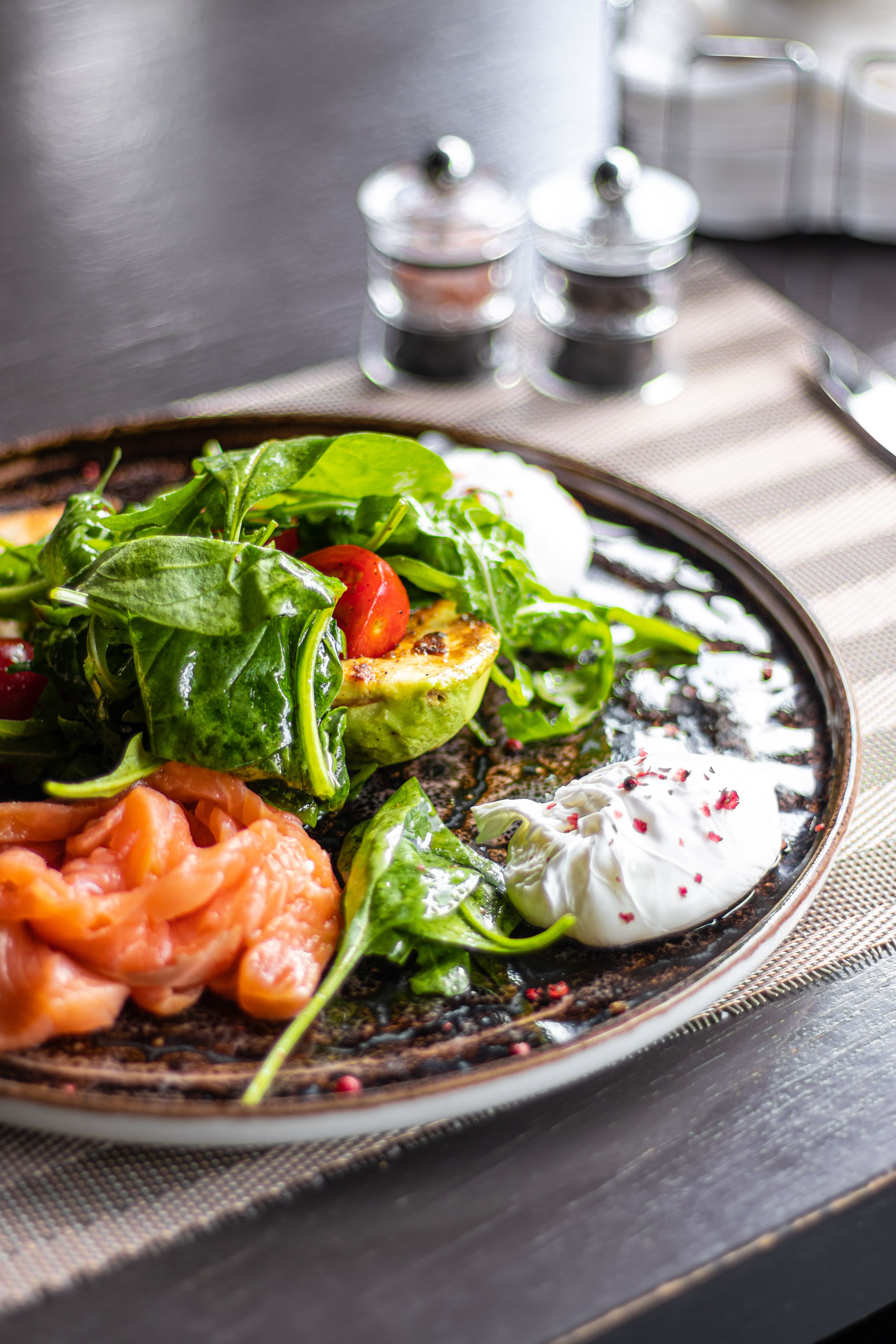 Fresh gourmet salad featuring smoked salmon, avocado, and poached eggs, perfect for a healthy meal.