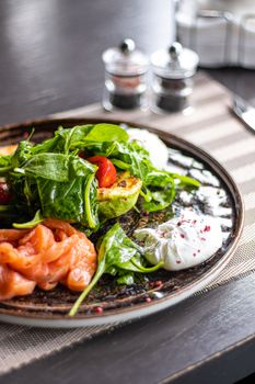Fresh gourmet salad featuring smoked salmon, avocado, and poached eggs, perfect for a healthy meal.