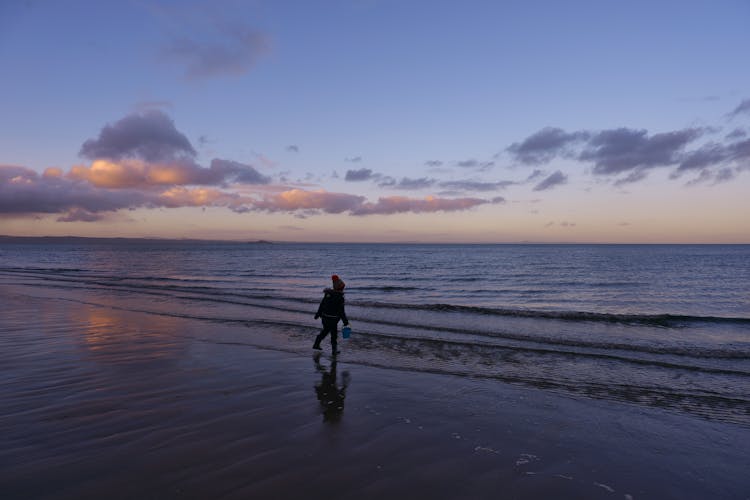 A Kid Walking On The Seashore 