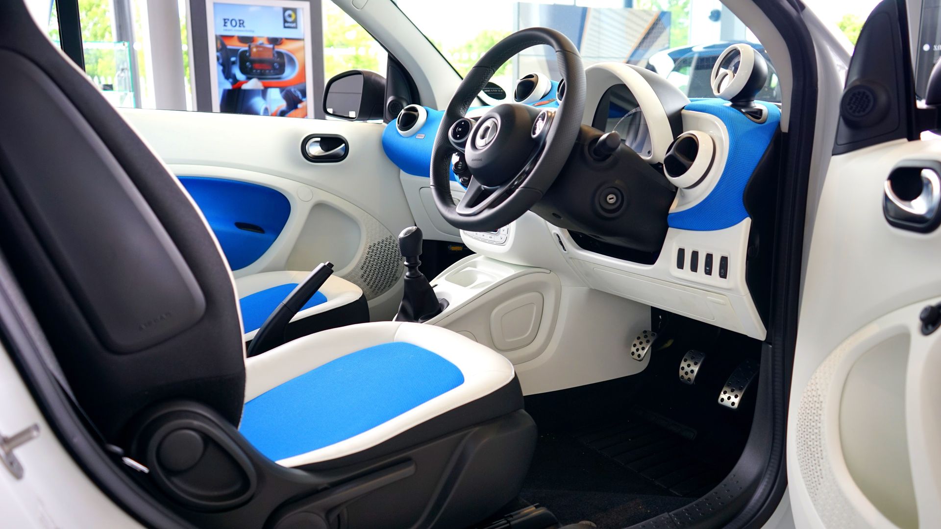 Explore the sleek blue and white interior of a luxury modern vehicle featuring advanced technology and style.