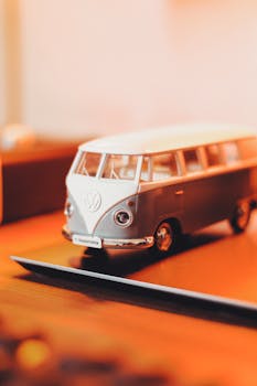 Selective focus on a classic Volkswagen Kombi toy model in warm indoor lighting.