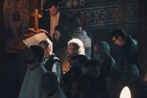Free A solemn gathering of worshippers in traditional attire during a religious ceremony inside a Romanian church. Stock Photo