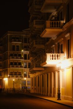 A beautifully lit street at night featuring elegant residential buildings and ornate balconies in Doha, Qatar.