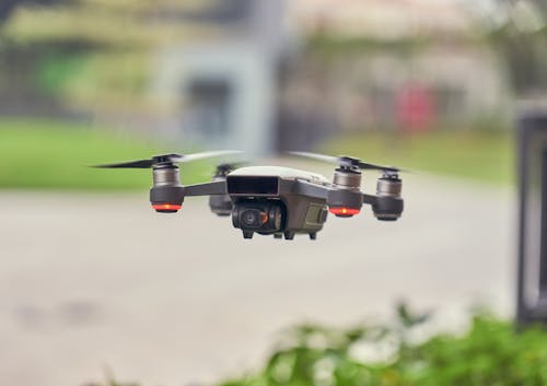 Selective Focus Photo of Flying Gray Quadcopter