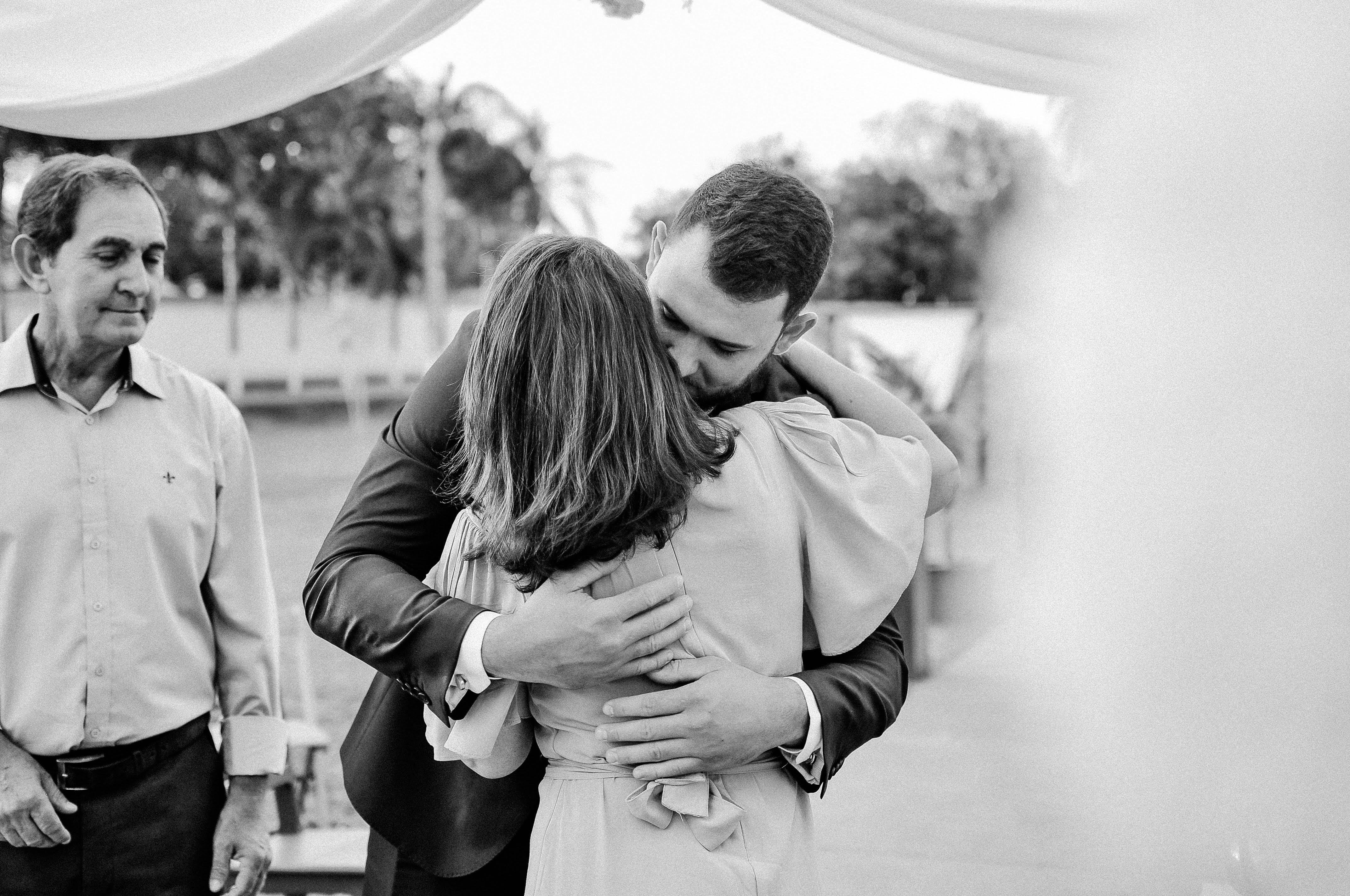 a man and woman hugging at each other