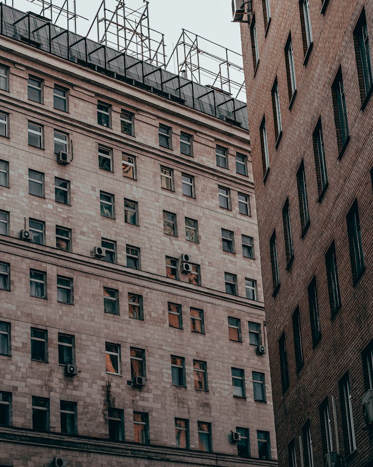 Air Conditioners Hanging On Brown Brick Buildings 