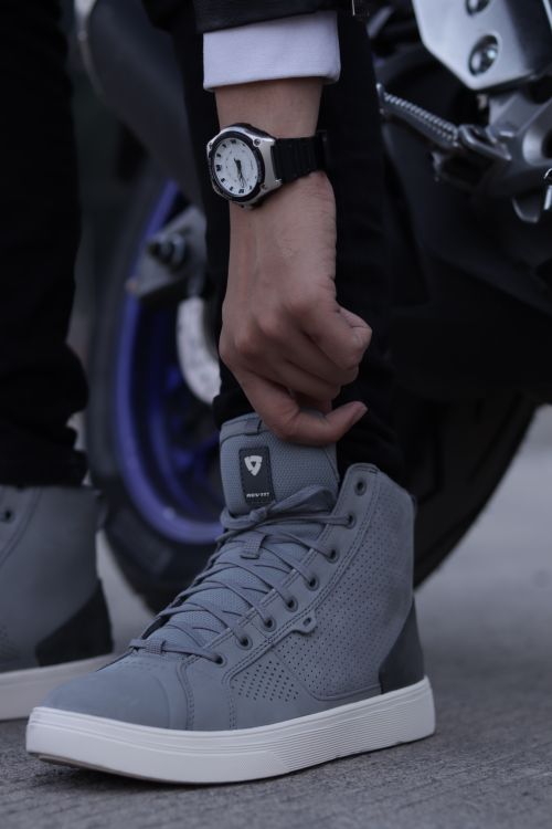 Free Close-up of gray sneakers with a wristwatch, capturing urban style and fashion trends. Stock Photo