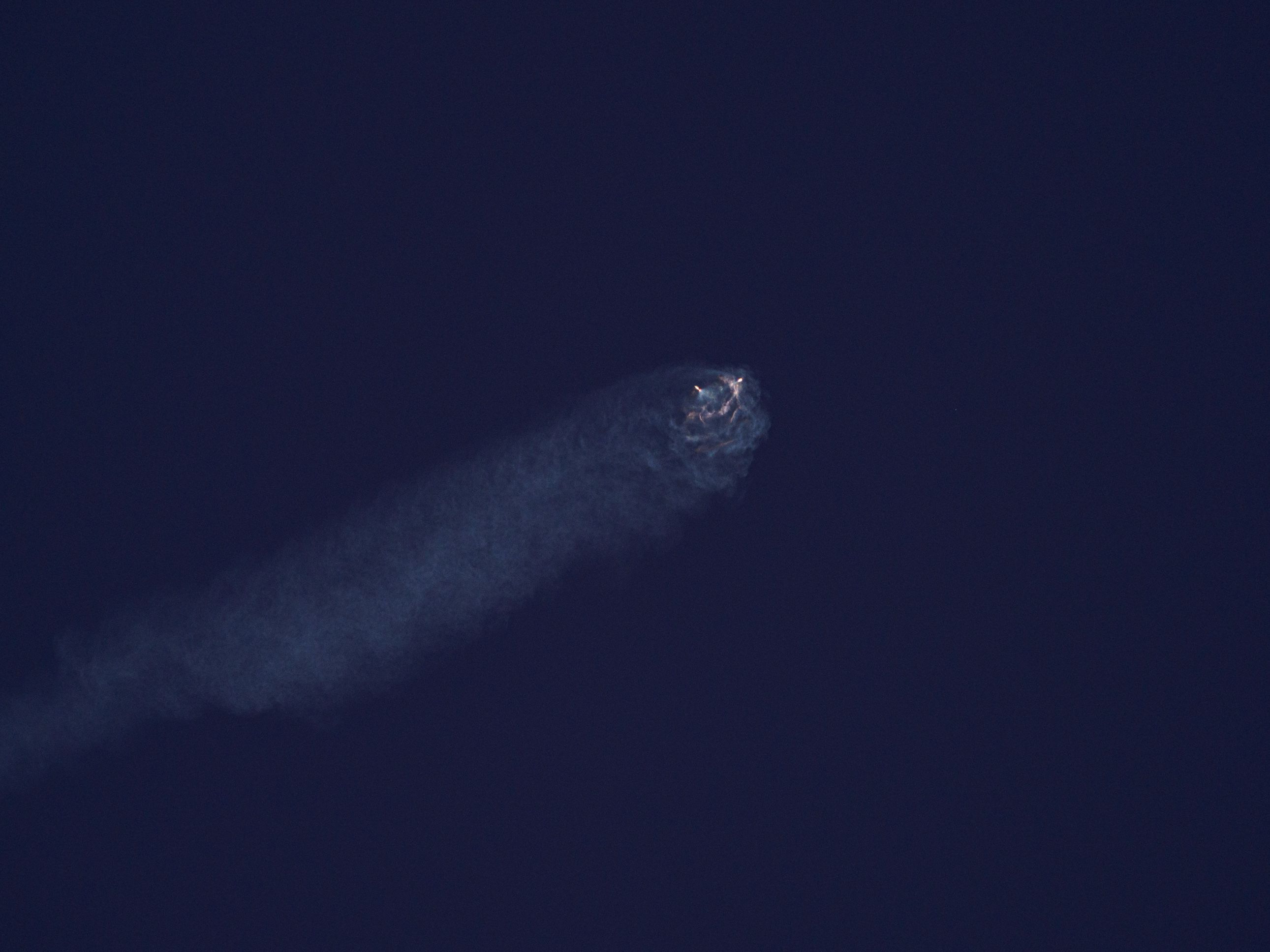 Imajen hatudu SpaceX Starship iha momentu splashdown iha Oseanu Indiku, ho lakan no asu boot, hanesan simbolu ba teknolojia e