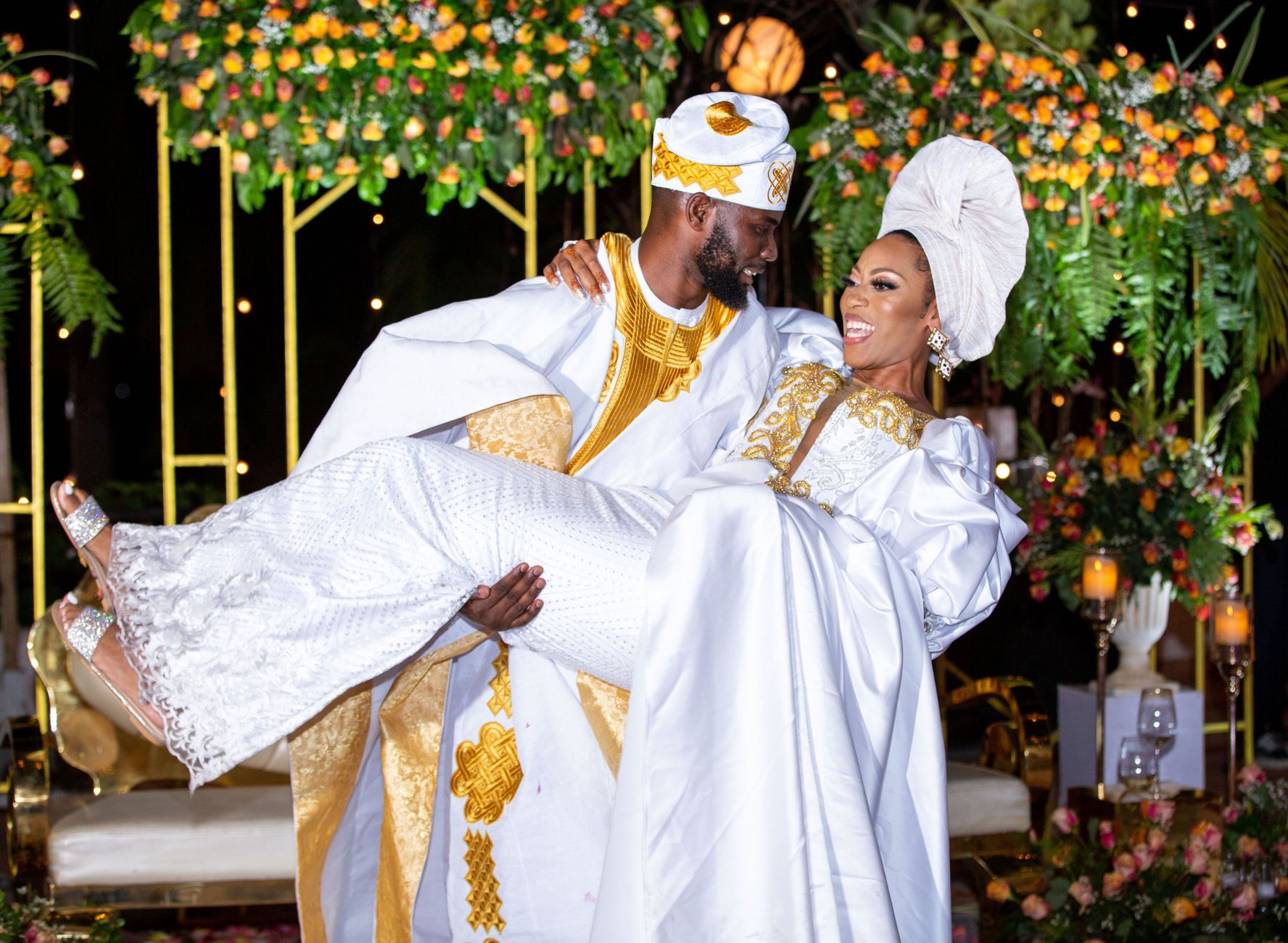 Joyful couple in traditional African attire celebrates their wedding with a lively outdoor ceremony.