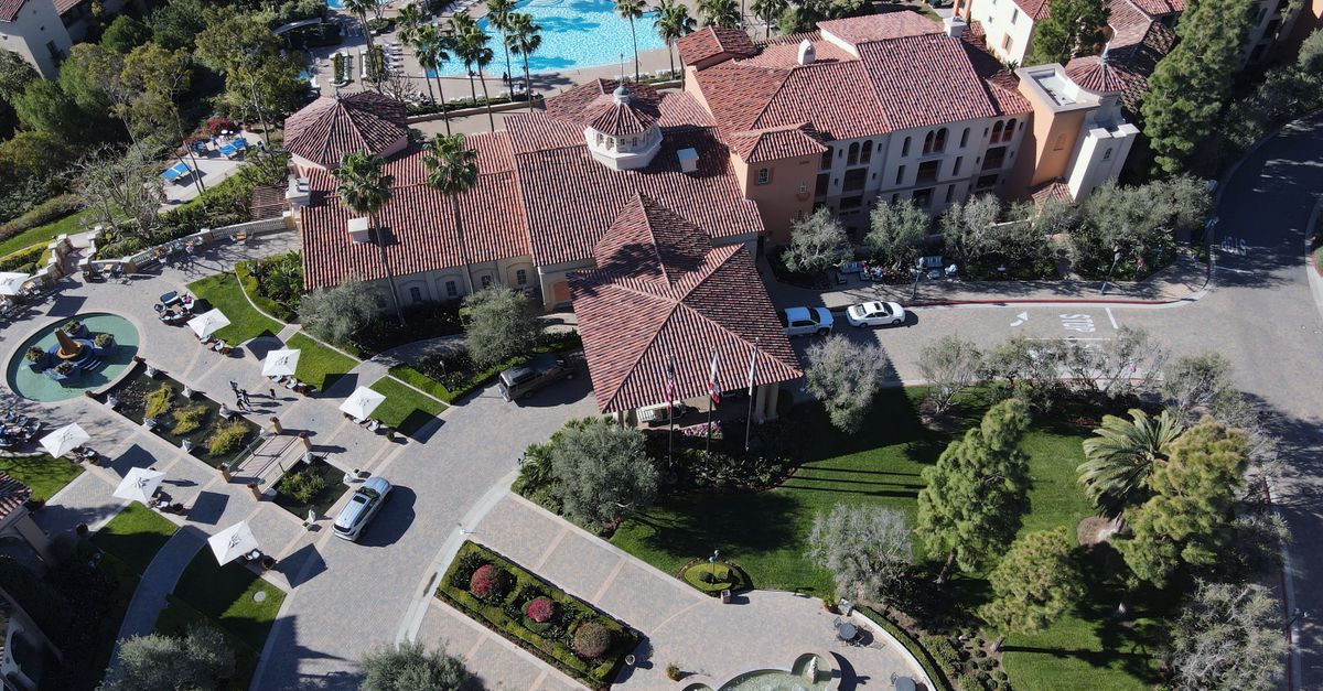 Stunning aerial view of a luxury resort with pools and lush greenery in Newport Beach, California.