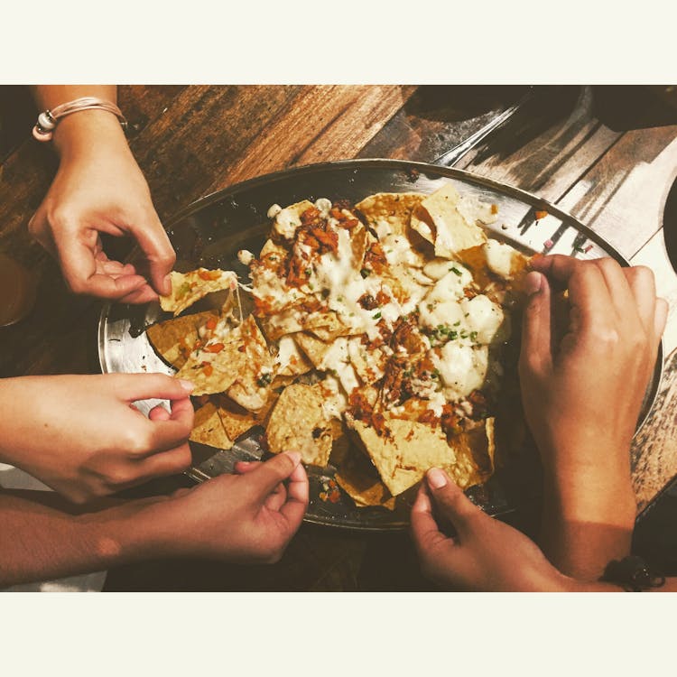 Close-up Photography of People Picking Nachos Chips