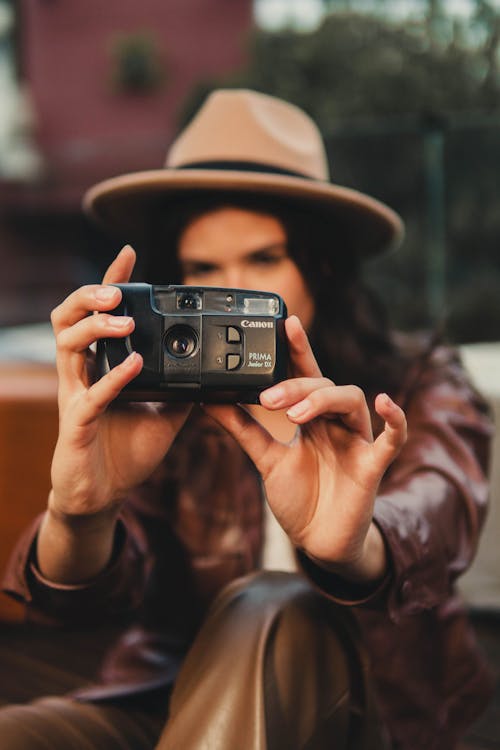 Stylish Man in Brown Leather Jacket and Pants Holding Black Camera