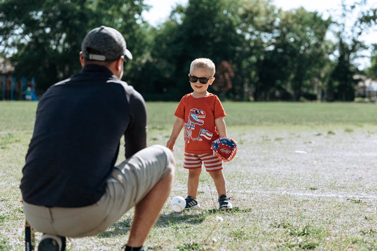 Dad Playing Baseball With Son In Park 