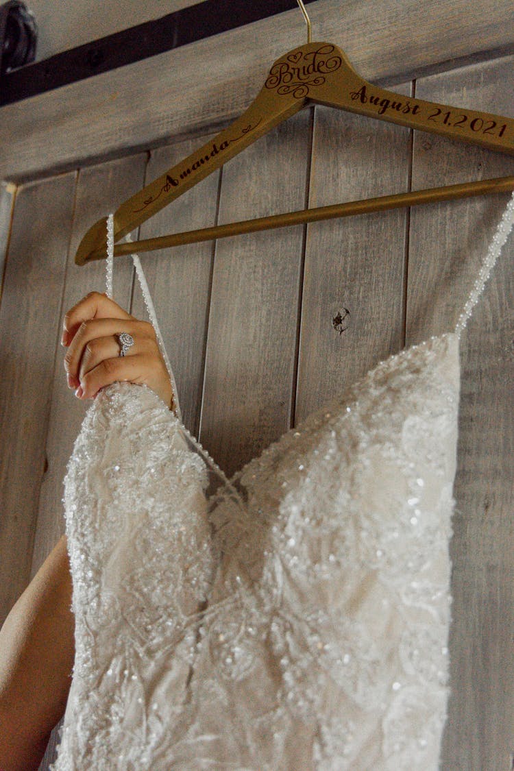 A Wedding Dress On A Wooden Hanger