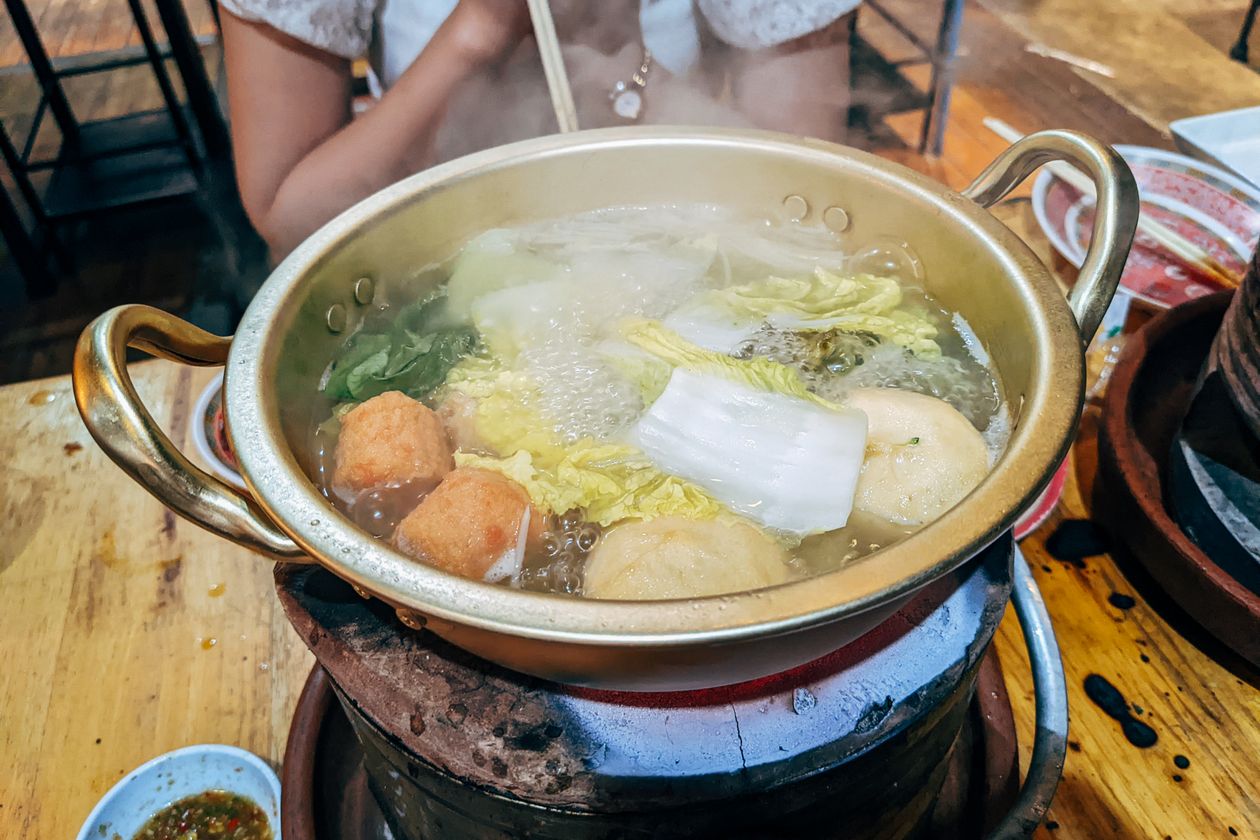 Nồi lẩu rau củ và chả viên đang sôi nghi ngút khói