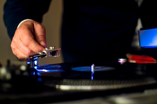 Person Holding a Phonograph's Tonearm 