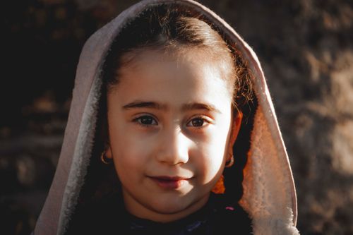 Free Close-up portrait of a young girl with a headscarf in warm sunlight. Stock Photo
