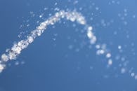 水滴悬浮在半空中的宏观镜头，背景是模糊的天空