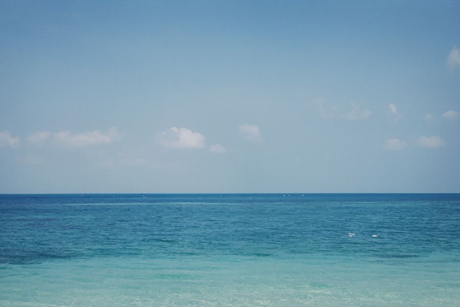 Peaceful ocean view with a clear blue sky and calm waters, perfect for relaxation and tranquility.