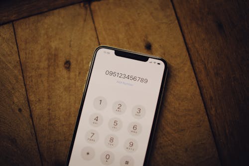 Close-Up Shot of a Mobile Phone on Wooden Surface