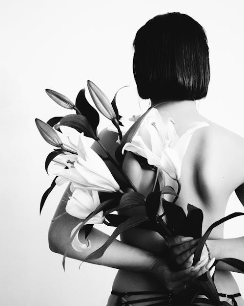 Free Back View of Woman Holding Flowers Stock Photo