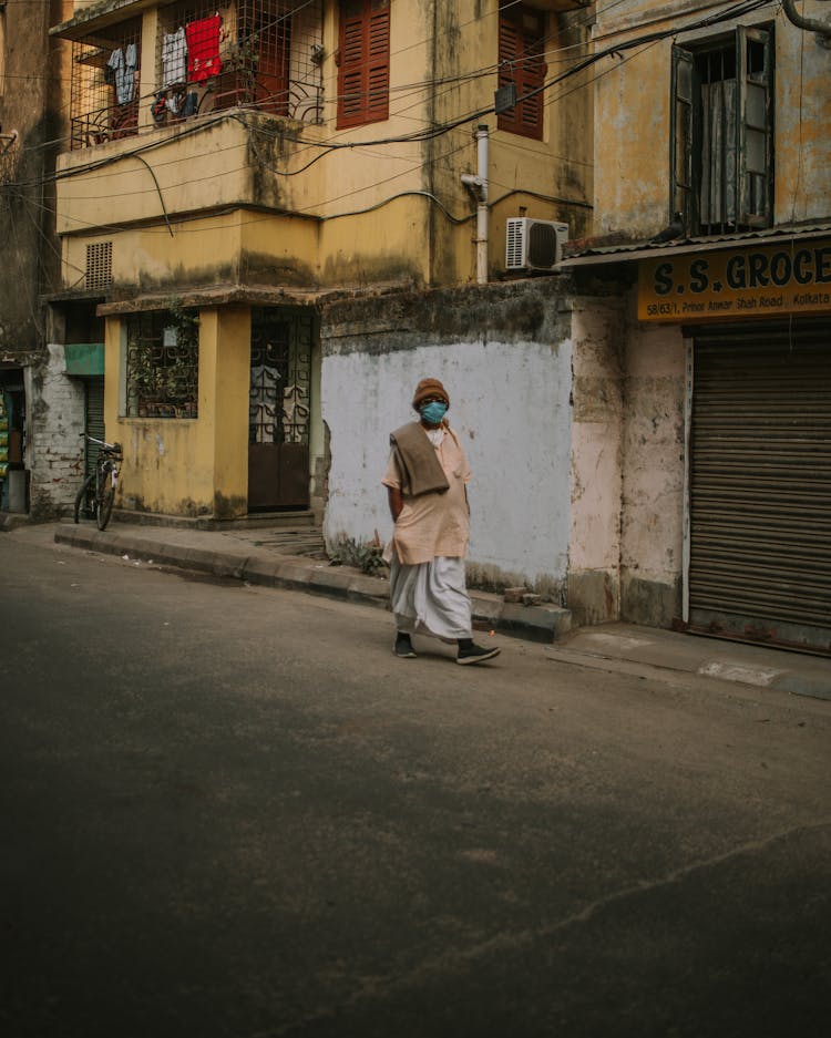 Woman In Face Mask Walking Down The Street