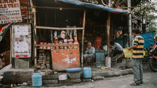 Free A bustling street view featuring a local Indian shop with customers and vendors. Stock Photo
