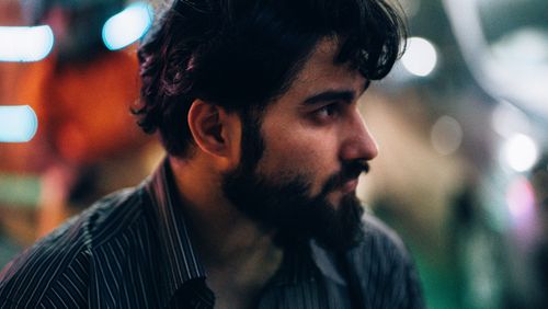 Free Close-up profile portrait of a bearded man at night with bokeh lights in the background. Stock Photo