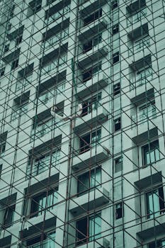 Photo showcasing scaffolding on a tall building under construction, viewed from below.