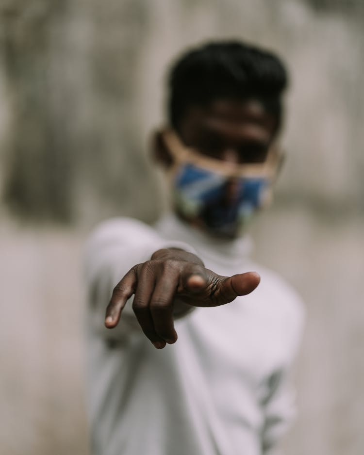 Man In Face Mask Pointing At Screen