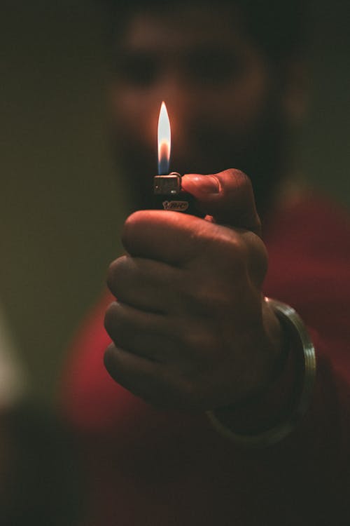 A Hand Holding a Lighter with Flame